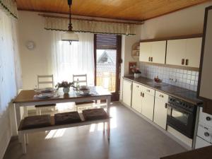 una cocina con mesa y un tablero asterisco en Schöne Ferienwohnung in Kärnten Hunde gerne auf Anfrage, en Sankt Veit an der Glan