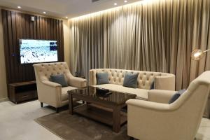 a living room with two couches and a tv at جولدن نايت in Jeddah