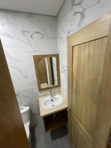 a bathroom with a sink and a mirror and a toilet at Hotel El Faro in Cartagena de Indias