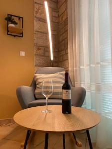 a bottle of wine sitting on a table with a wine glass at Apartman Olive in Tar