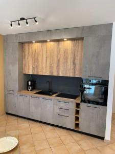a kitchen with a sink and a stove at Apartman Olive in Tar