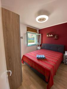 a red bedroom with a bed with a red blanket at Apartman Olive in Tar