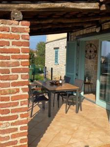 a patio with a table and chairs and a brick wall at Apartman Olive in Tar