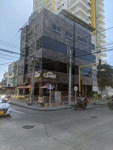 a building on the corner of a street with a motorcycle at Hotel El Faro in Cartagena de Indias