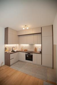 a kitchen with white cabinets and a stove top oven at Apartman Kuburica in Trebinje