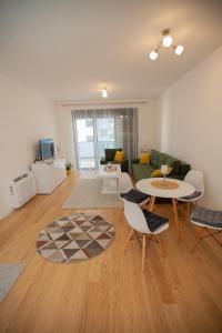 a living room with a couch and a table and chairs at Apartman Kuburica in Trebinje