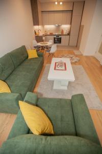 a living room with a green couch and a table at Apartman Kuburica in Trebinje