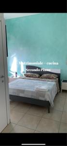 un letto in una camera con parete blu di Enza Vacanze a Santa Maria di Castellabate