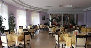 Pizzo Beach Club Apartment Ginevra في بيتسو: غرفة طعام مع طاولات وكراسي في مطعم