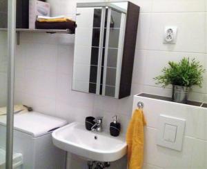 Trendy & Cozy Apartment at Heroes' Square في بودابست: حمام أبيض مع حوض ومرآة