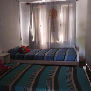 1 dormitorio con 1 cama con cortina y ventana en Duplex Olavarría en Olavarría