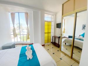 Habitación de hotel con cama y espejo en Hostal Carliza, en Puerto Ayora