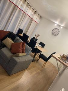 - un salon avec un canapé, une table et un réveil dans l'établissement Appartement spacieux et lumineux à Sarcelles, à Sarcelles