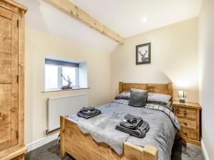 a bedroom with a wooden bed and a window at Headlands Farm in Flash
