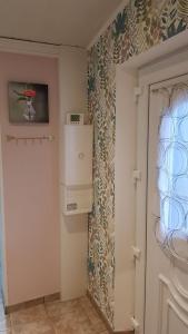 a kitchen with a refrigerator and a door in a room at La Maison de Lucette in Fourmies