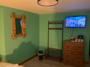ein Schlafzimmer mit grünen Wänden, einer Holzkommode und einem Spiegel in der Unterkunft ISLAND LODGE on the Hoe, Barbican, Free Limited Parking, Dogs friendly , Perfect for Ferry terminal in Plymouth
