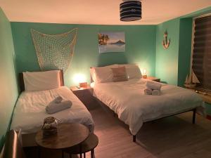 two beds in a room with green walls at ISLAND LODGE Since 1835 Barbican, Free Limited Parking, Perfect for Ferry terminal in Plymouth