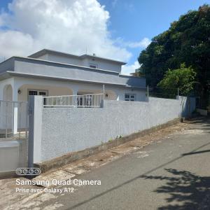 una casa blanca con una valla delante en Chez mimi 2, en Mahébourg