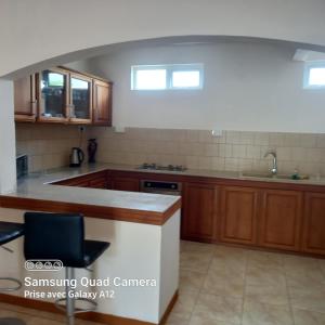 a kitchen with wooden cabinets and a counter top at Chez mimi 2 in Mahébourg