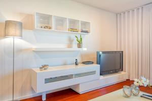 フンシャルにあるSeculo XXI-U, a Home in Madeiraの白いリビングルーム(テレビ、テーブル付)