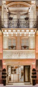 un bâtiment avec un balcon au-dessus dans l'établissement Hotel Louvre Saint-Honoré, à Paris