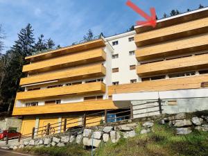 a tall white building with a red object in front of it at L’Eperon Center Crans wonderful view in Crans-Montana