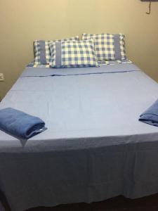 a large bed with blue pillows on top of it at Casa de praia para sonhar in Luis Correia