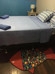 a bedroom with a bed with a quilt on the floor at Casa de praia para sonhar in Luis Correia