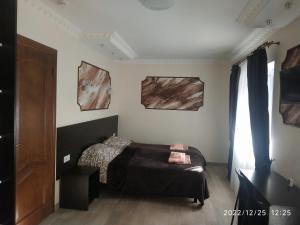 a bedroom with a bed and two paintings on the wall at NestG Guest House in Pilipets