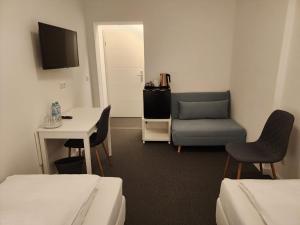 a room with a bed and a chair and a table at Davin City Aparments - Self-Check-In in Hamburg