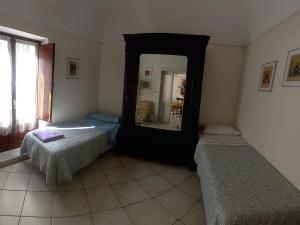 um quarto com 2 camas e um espelho grande em La sartoria em Centuripe