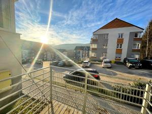 a balcony with a car parked on a street at Apartamenty Superior Izery Cicha in Świeradów-Zdrój