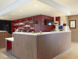 a bar in a hotel room with red cabinets at Campanile Le Mans Est in Le Mans