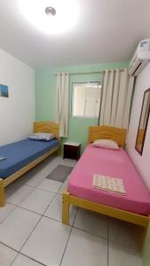 フロリアノポリスにあるPousada Mar Verdeのベッド2台と窓が備わる客室です。