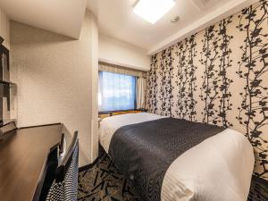 a hotel room with a bed and a desk at APA Hotel & Resort Niigata Ekimae Odori in Niigata