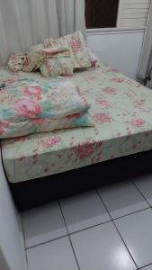 a small bed with a floral bedspread and pillows on it at Apartamento Salvador in Salvador