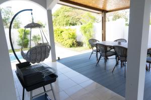 un portico coperto con tavolo e sedie di VILLA SANTIBANEZ - Villa avec piscine à St André a Le Patelin