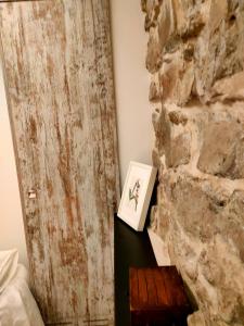 Habitación con pared de piedra y una foto en una mesa. en Cal Marsal en Aitona