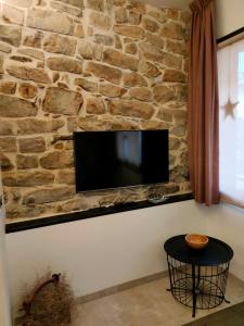 uma parede de pedra com uma televisão de ecrã plano numa parede em Cal Marsal em Aitona