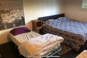 パリにあるCharming studio at the heart of 14 arrondissementのベッドが2つあり、壁に絵が飾られている寝室