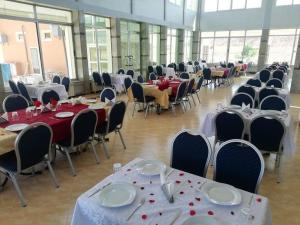 un salón de banquetes con mesas y sillas con platos y servilletas en HOTEL LA POMME ZAIDA en Zaida