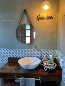 uma casa de banho com um lavatório e um espelho. em Casa da Sandra em Florianópolis
