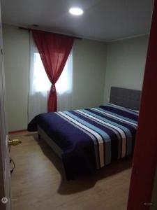 una camera da letto con un letto e una finestra di Apartamento por dia a Puerto Montt