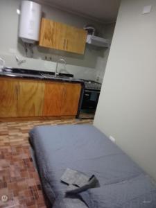 a room with a bed in a kitchen with a sink at Apartamento por dia in Puerto Montt