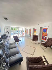 a living room with a leather couch and chairs at Hotel La Guajira in Ríohacha