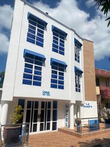 a white building with blue windows on the side of it at Hotel La Guajira in Ríohacha