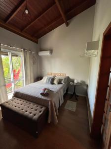 um quarto com uma cama grande e uma janela em Casa da Sandra em Florianópolis