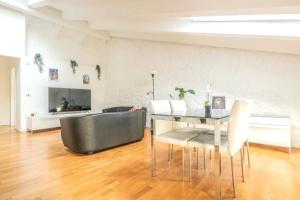 a dining room with a table and chairs at [Penthouse] Piazza San Giacomo in Udine +2 photos