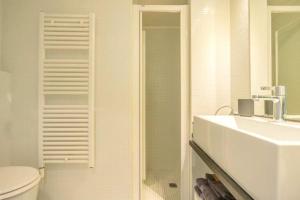 een badkamer met een wastafel, een toilet en een spiegel bij [Penthouse] Piazza San Giacomo in Udine