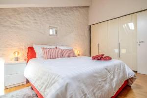 een slaapkamer met een groot wit bed met rode kussens bij [Penthouse] Piazza San Giacomo in Udine